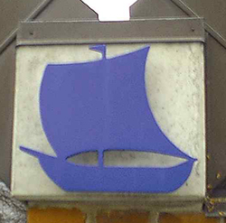 Et blåt kirkeskib-symbol monteret på en murstensvæg.