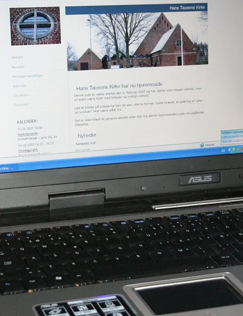 En bærbar computer, der viser Hans Tausens Kirkes hjemmeside på skærmen.