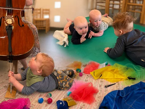 Babyer der kravler på gulvet til babysalmesang.