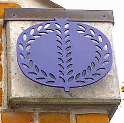 Et blåt granatæble-symbol monteret på en murstensvæg.