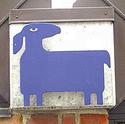 Et blåt lam-symbol monteret på en murstensvæg.